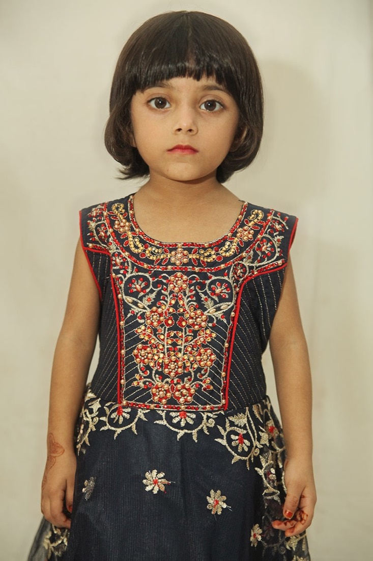 Close-up of a navy frock with red and gold embroidery made by Faraak, Karachi